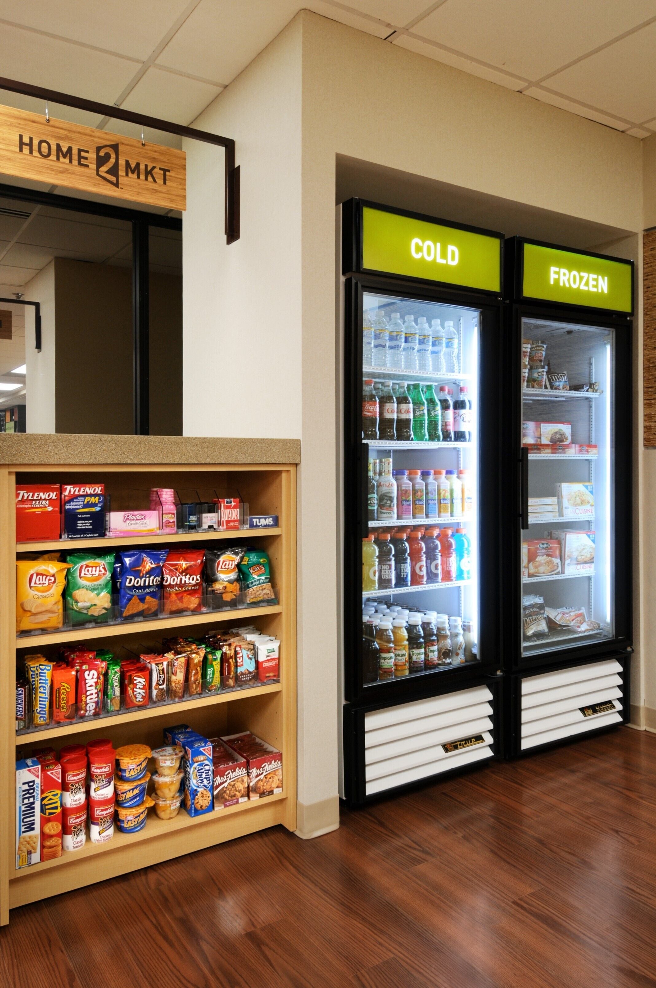 Een afdeling voor snacks en drankjes met schappen vol diverse snacks en dranken, en twee koeltoogjes, waarvan er een is voor bevroren producten.