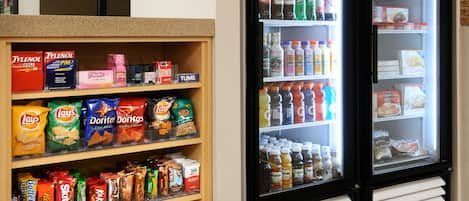 A snack and beverage section with shelves stocked with various snacks and drinks, and two refrigerated display cases labeled "COLD" and "FROZEN".