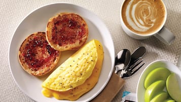 Un plato con tostadas, huevos revueltos y una taza de café.