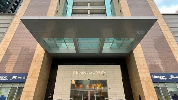 A modern building with a prominent entrance labeled "8 Boulevard Walk". - Vacay Lettings - 8 Boulevard Walk (Dubai)