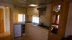A compact kitchen with a sink, stove, and cabinets. - Dutch House in Łazy near Lake Jamno (Łazy)