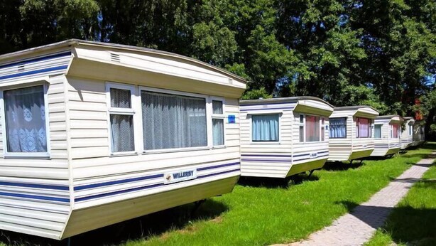 A row of mobile homes with a similar design, featuring a flat roof and a single-story structure. - Dutch House in Łazy near Lake Jamno (Łazy)