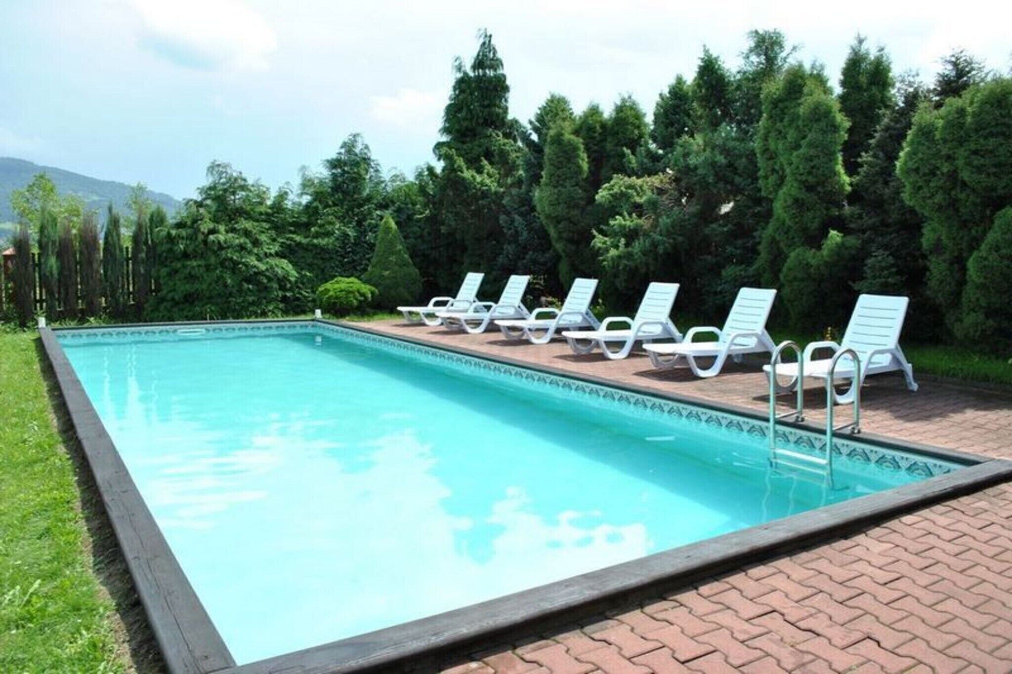 Una piscina rectangular con borde de azulejos, rodeada por un patio de ladrillo.