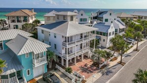 Un quartier résidentiel situé sur la côte, composé de plusieurs maisons à deux étages dotées de balcons et offrant une vue sur l’océan.
