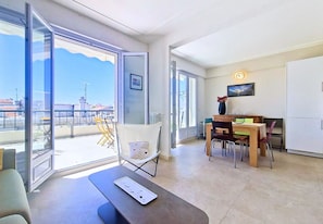 A modern apartment with a balcony, a dining area, and a kitchen.