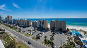 Ein Hotelkomplex an der Küste mit mehreren Gebäuden, einem Parkplatz und Blick auf den Strand.