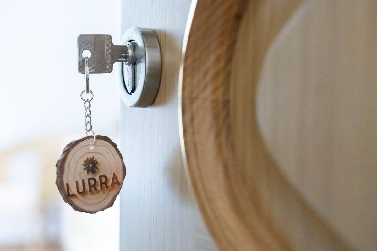 A door with a keyhole and a wooden keychain with the name "LURRA" engraved on it.