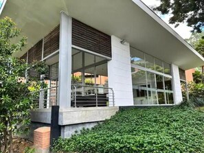 Un edificio moderno con techo plano, ventanas amplias y base de hormigón.