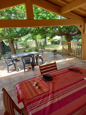 An outdoor patio with a table and chairs, a covered seating area, and a view of the surrounding garden. - Quiet location at the end of a lane in a green setting 4-bedroom villa  (st Bazille de la sylve)