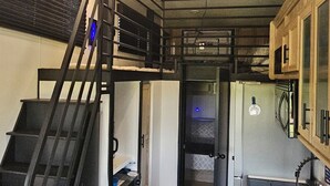 Una cocina compacta con una isla central, horno empotrado y microondas.
