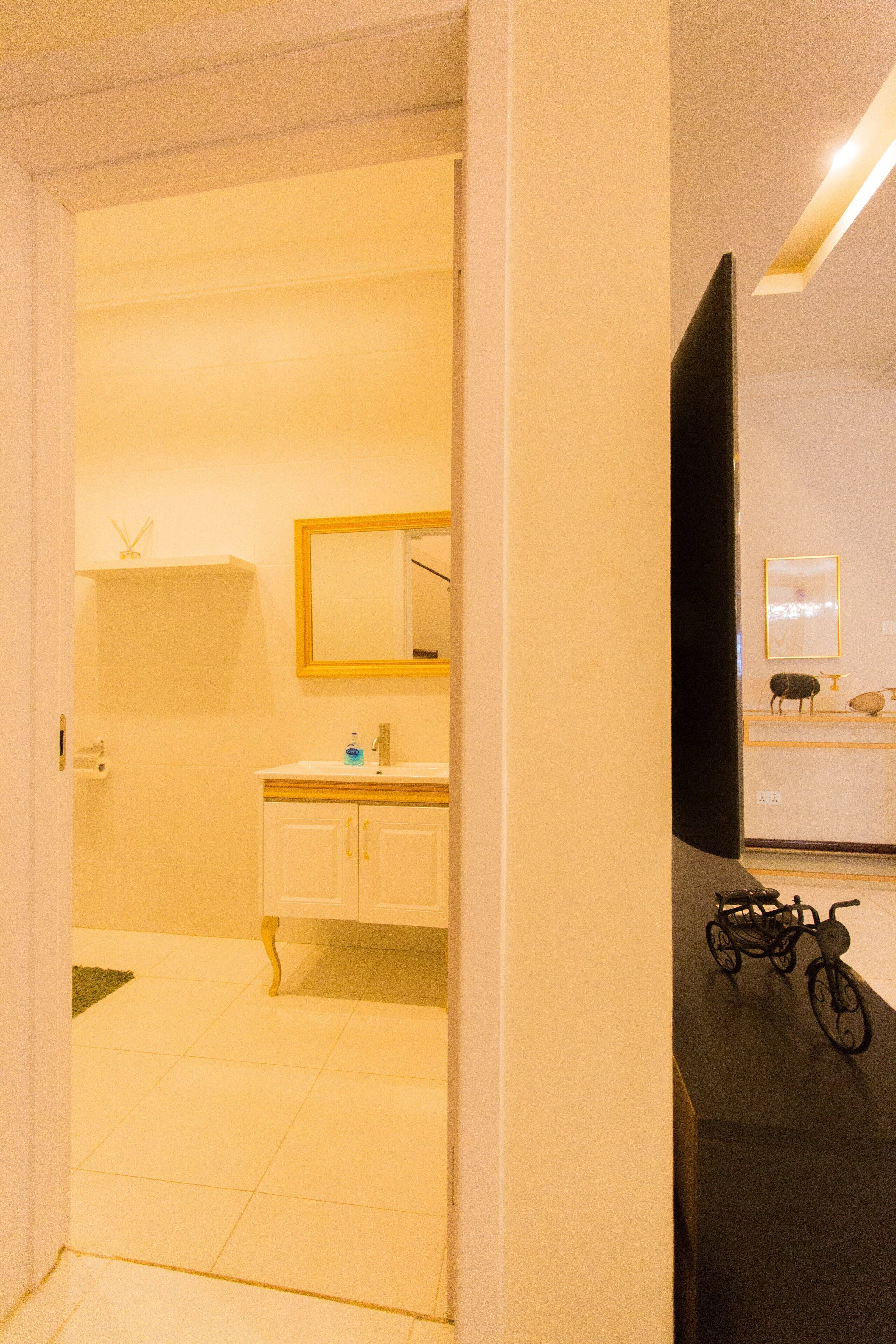 Une salle de bain d’hôtel avec un lavabo blanc, un miroir et un vélo dans un coin.
