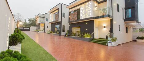 Un complexe résidentiel moderne comprenant plusieurs maisons à deux étages, une allée pavée et des espaces verts bien entretenus.