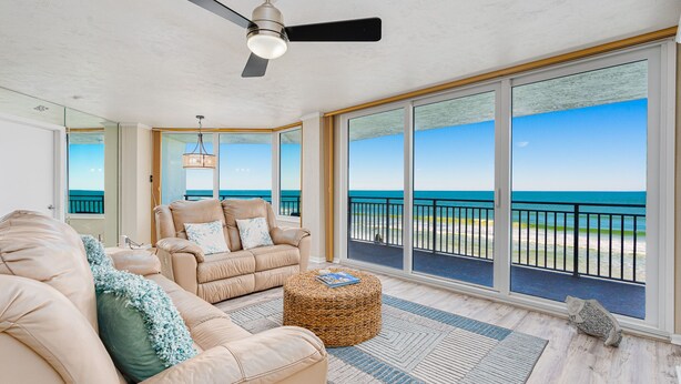 A spacious balcony with a view of the ocean, a ceiling fan, and a wicker ottoman. - NEW!Pool!Hot Tub!Oceanfront! Peninsula #303 (Daytona Beach)