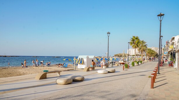 A beachside promenade with a clear sky, palm trees, and beach umbrellas. - Aeri Home - At Nea Chora beach w. Parking included (Chania)