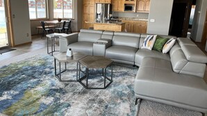 Una sala de estar moderna con un sofá modular, una mesa de centro y un comedor con sillas.