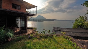 Ein Haus mit einem Balkon mit Blick auf einen See und ein Berg in der Ferne.