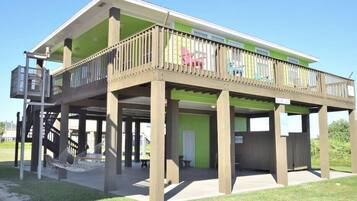 A two-story building with a balcony, a staircase, and a hammock.