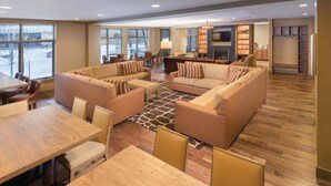 A spacious living area with a sofa set, a dining table, and a fireplace. - Presidential Unit at a World Class Ski Resort
 (Avon)