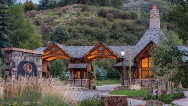 A lodge with a stone facade, wooden entrance, and a chimney. - Presidential Unit at a World Class Ski Resort
 (Avon)