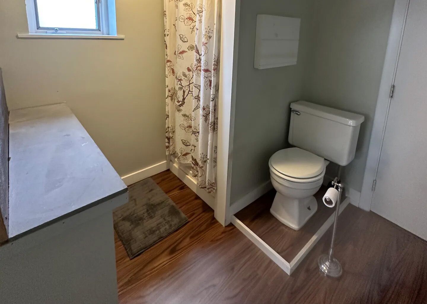 Ein kleines Badezimmer mit Toilette, einer Duschkabine und einem Fenster.