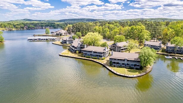 A lakeside property with multiple buildings, docks, and a boat.