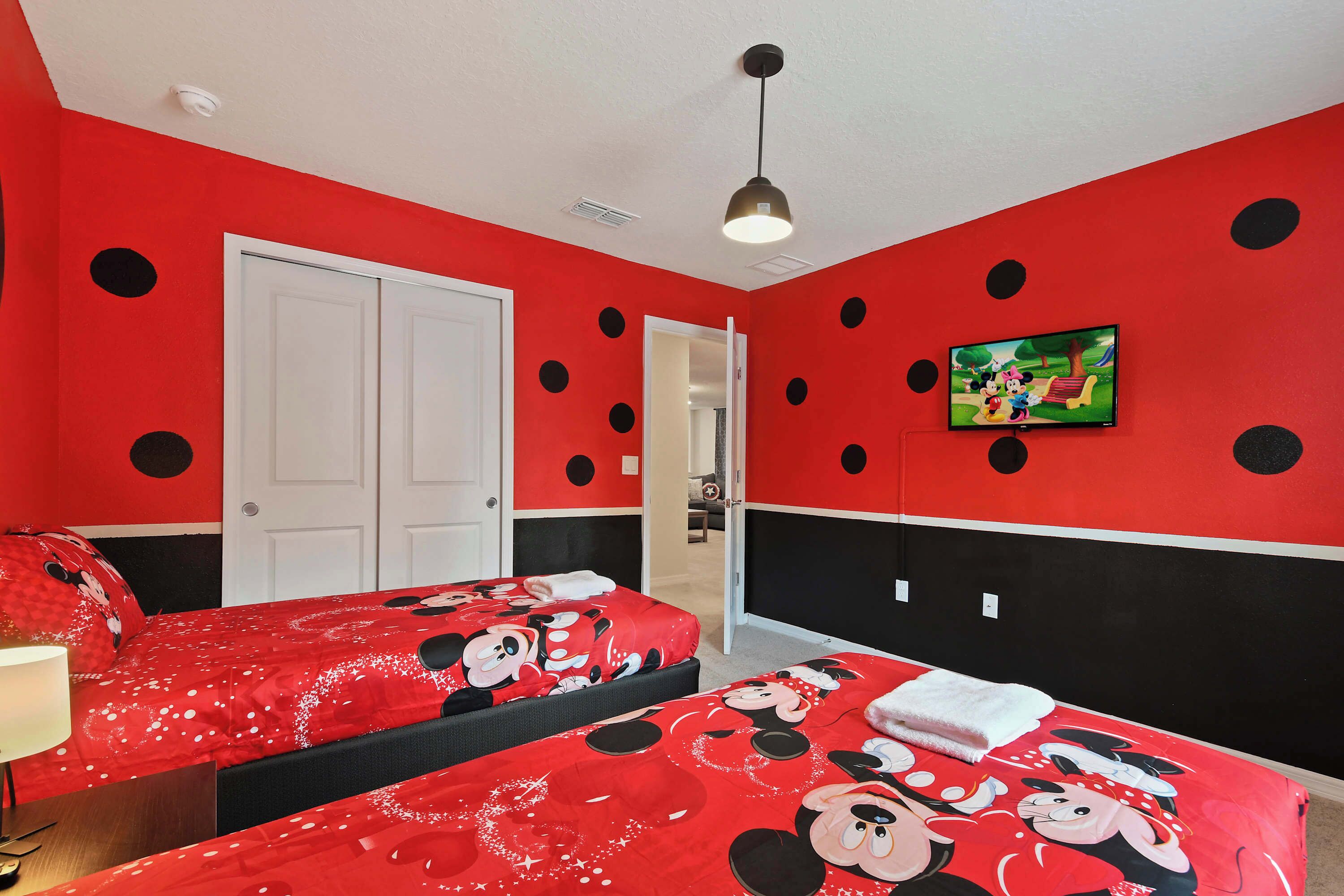 A room with two beds, a TV, and a door.