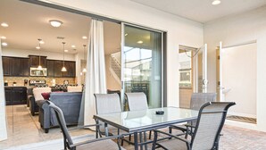 A modern kitchen with dark cabinets, a microwave, and a stove. - Free Waterpark Access! 5br Resort Townhome w/ Pool (Kissimmee)
