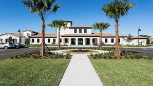 A two-story house with a tiled roof, surrounded by palm trees and a well-maintained lawn. - Free Waterpark Access! 5br Resort Townhome w/ Pool (Kissimmee)