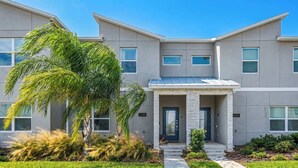 A modern two-story building with a flat roof, large windows, and a central entrance with a door. - 4BR Retreat in Champions Gate w/ Private Pool (Davenport)
