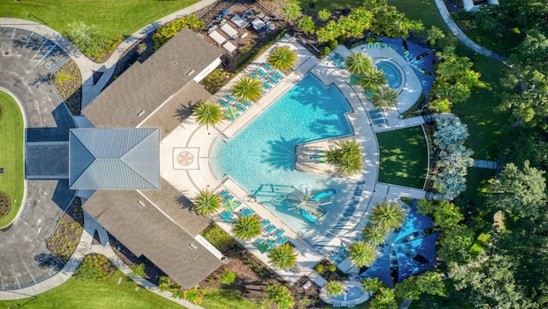 An aerial view of a resort with a central swimming pool, multiple lounge areas, and palm trees. - Veranda Palm Resort 12br Pool Spa Villa 2528 (Kissimmee)