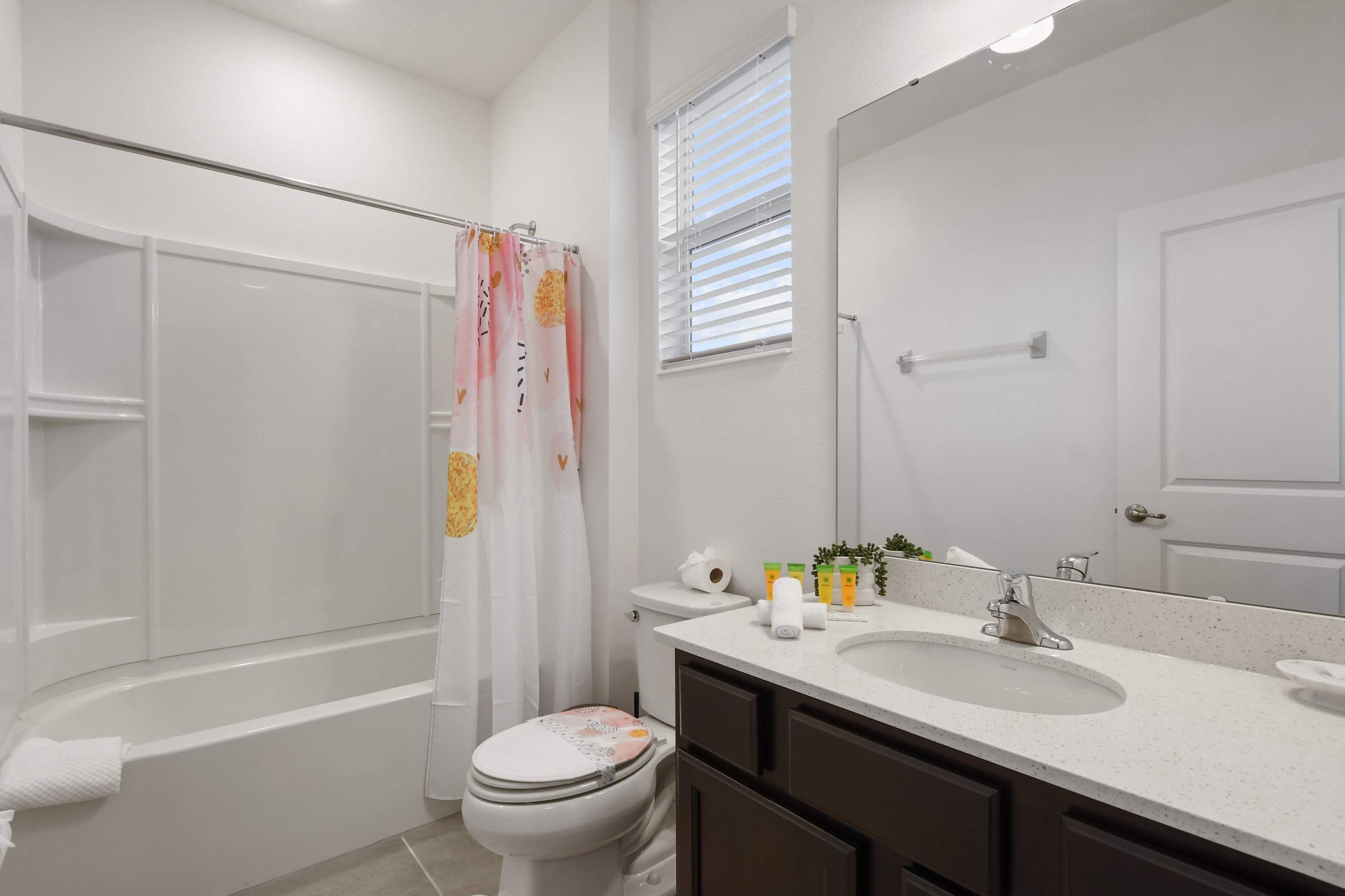 Un bagno moderno con vasca, servizi igienici e lavandino.