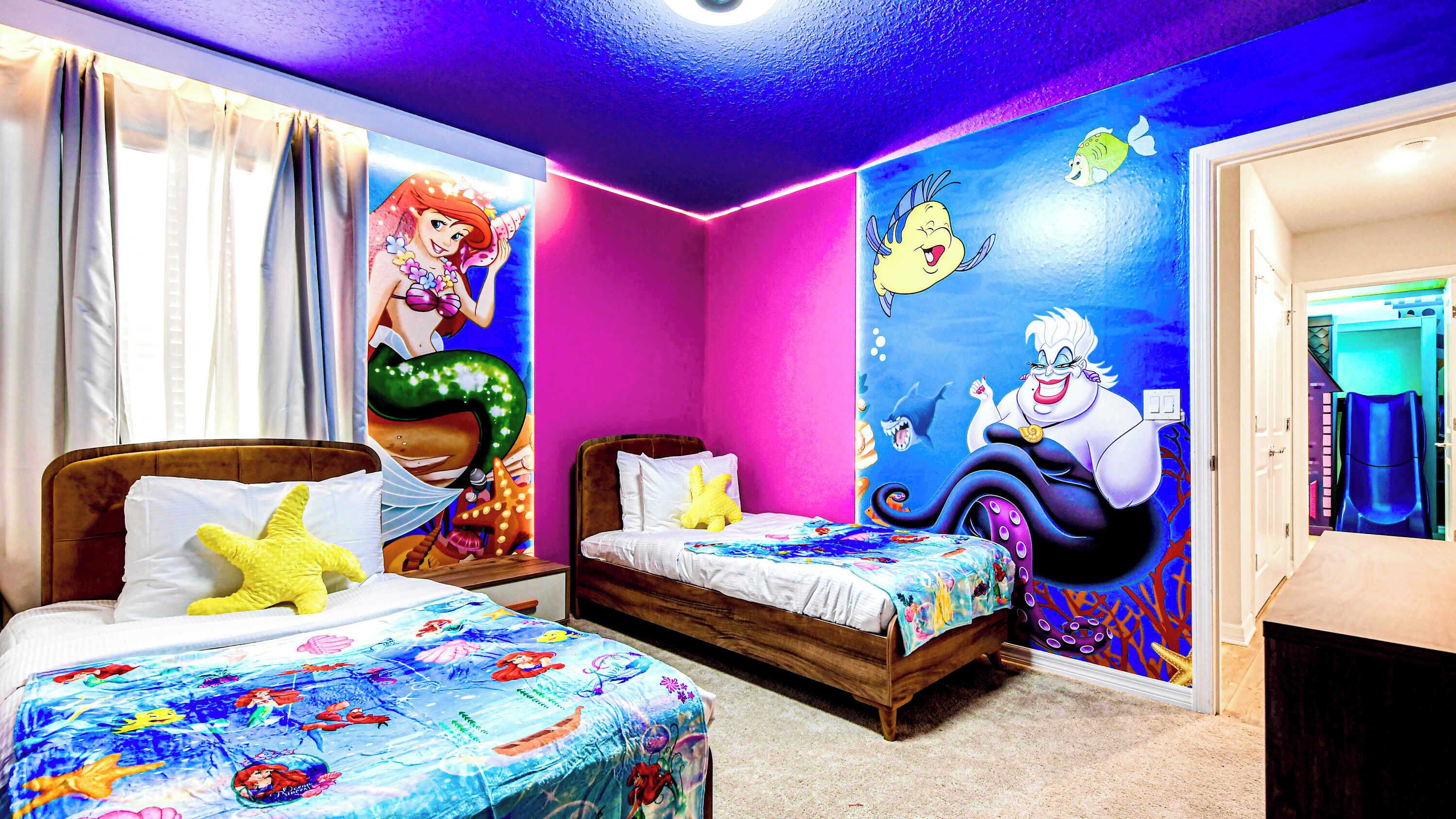 A bedroom with two beds, colorful wall murals, and a bright ceiling light.