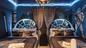 A room with two beds, each with a unique headboard design, a chandelier, and a mural on the wall. - 7BR Solterra Resort - Newly Renovated Home w Pool (Davenport)