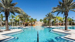 A large, clear swimming pool with palm trees and lounge chairs around it. - 7BR Solterra Resort - Newly Renovated Home w Pool (Davenport)