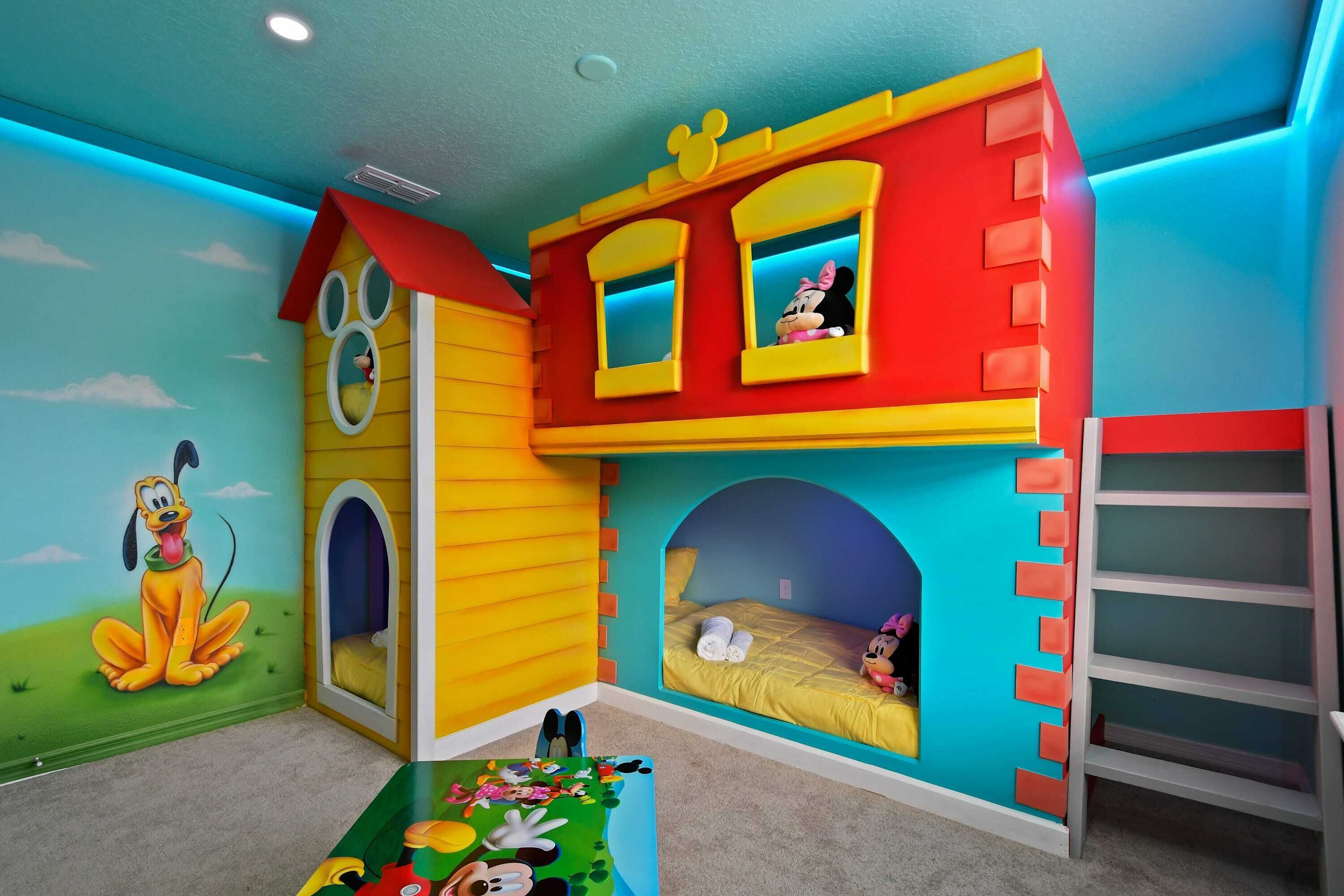 Ein Spielzimmer für Kinder mit Wandmalerei von Mickey Mouse, einem Spielhaus und einem Etagenbett.