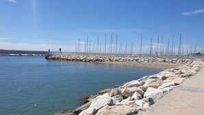 A coastal area with a rocky breakwater, calm water, and numerous tall poles. - Magnifique, et Luxueux Appartement en Top Résidence à Benalmadena (Benalmádena)