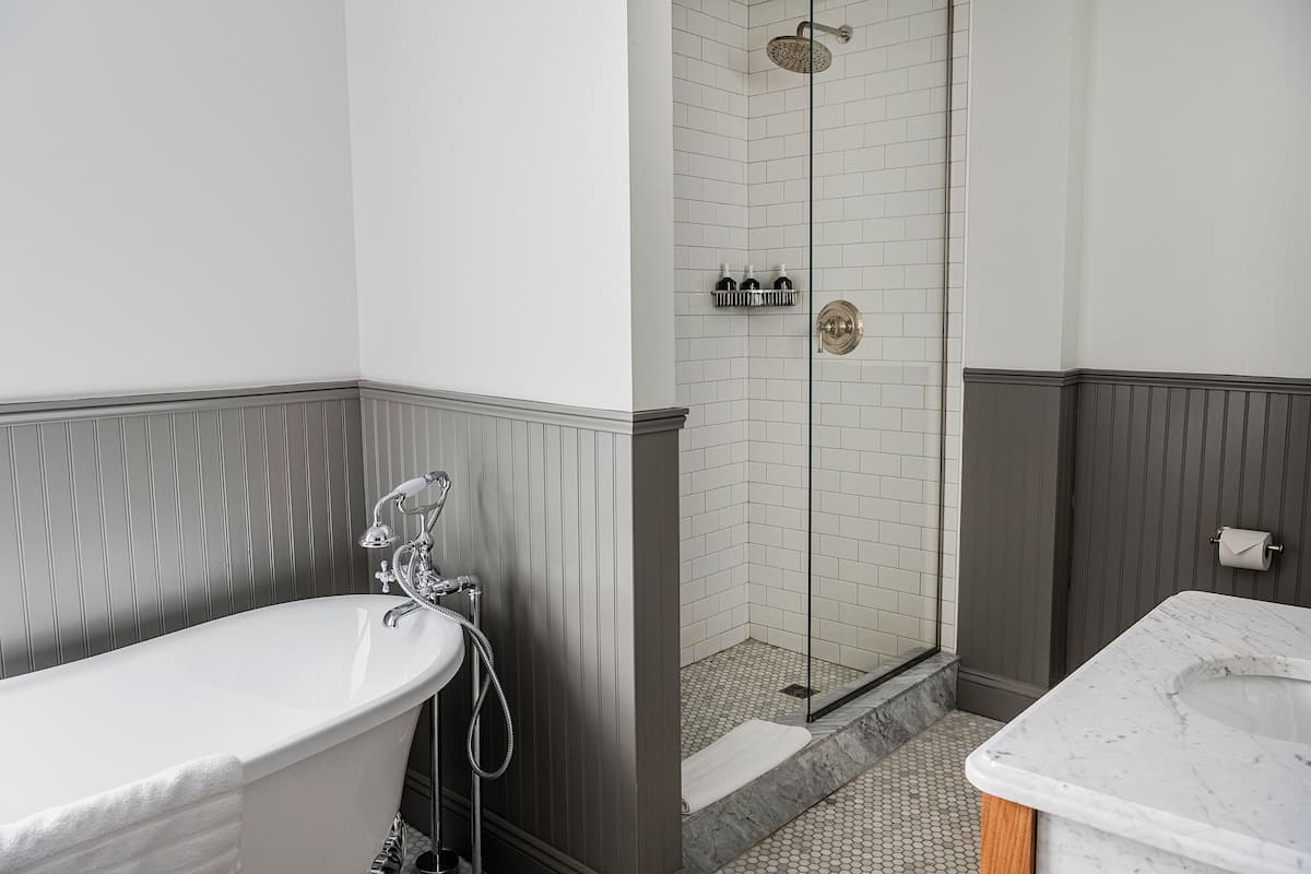 A bathroom with a freestanding bathtub, a shower with a glass door, and a marble sink.