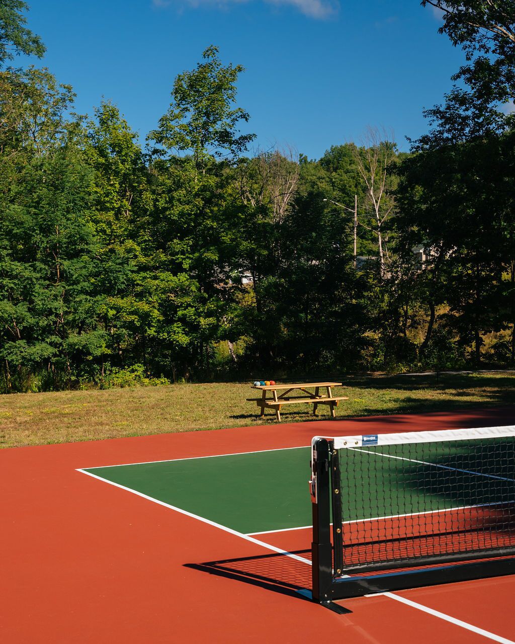 A tennis court with a picnic table and a net.