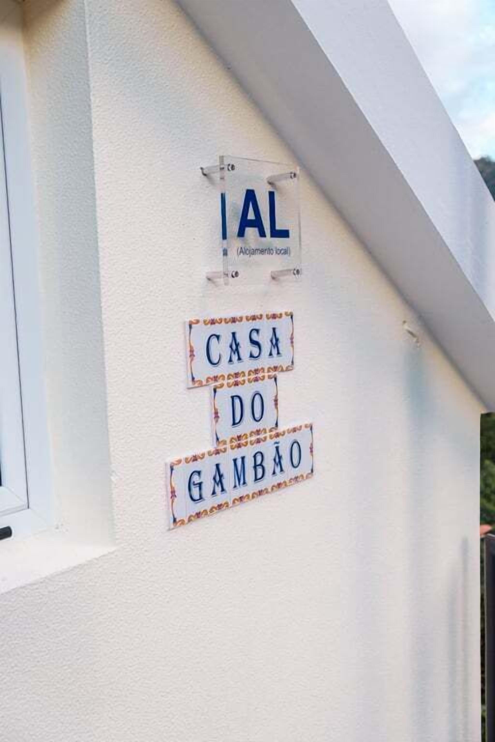 Un edificio bianco con un cartello che riporta "IAL" e un altro cartello sottostante che dice "CASA DO GAMBAO".