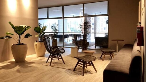 A modern lounge area with large windows, a sofa, chairs, and potted plants. - NEW LISTING! Mandala: Serenity, Luxury, and Nature! In Envigado. (Cali)