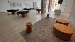 A spacious, well-lit room with a modern design, featuring a large table, several smaller tables, and a unique wooden column. - NEW LISTING! Mandala: Serenity, Luxury, and Nature! In Envigado. (Cali)
