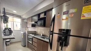 Une cuisine moderne dotée d’appareils électroménagers en acier inoxydable, d’un four encastré et d’un distributeur d’eau sur le réfrigérateur.