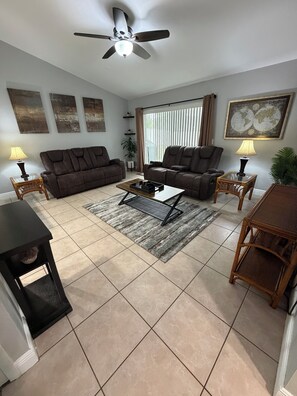A living room with two sofas, a coffee table, a floor lamp, and a ceiling fan. - 3/2 Home Minutes To All Theme Parks (Orlando)