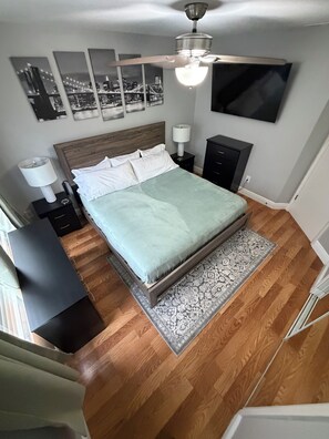 A bedroom with a bed, a nightstand, a lamp, a TV, and a ceiling fan. - 3/2 Home Minutes To All Theme Parks (Orlando)