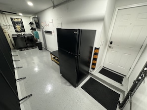 A kitchen with a black refrigerator, a sink, and a countertop. There is a door with a towel hanging on it. - 3/2 Home Minutes To All Theme Parks (Orlando)