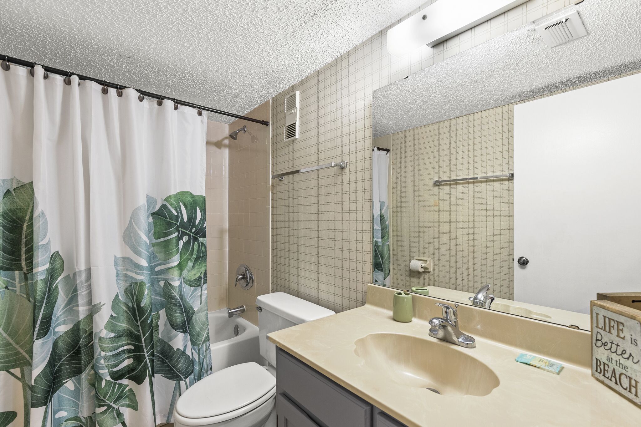 A bathroom with a toilet, sink, and shower.