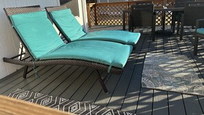 A deck with two lounge chairs and a table, surrounded by a wooden fence and a pergola. - Cozy and Comfortable home with easy access to Hwy 60 and Springfield! (Republic)