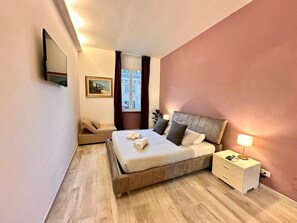 A bedroom with a bed, bedside table, lamp, and a painting on the wall. - C&Y Apt - Roma Vaticano - New Exclusive Penthouse (Roma)
