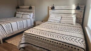 A room with two beds, each with a wooden headboard and patterned bedding. - Rafton 2 Home (Grafton)