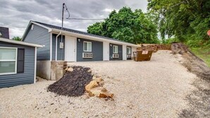 A two-story mobile home with a gravel driveway and a pile of mulch in front. - Rafton Inn Vacation Cottage 19 (Grafton)
